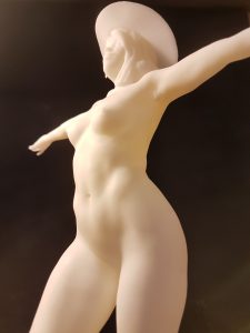 a nude woman standing wearing a hat